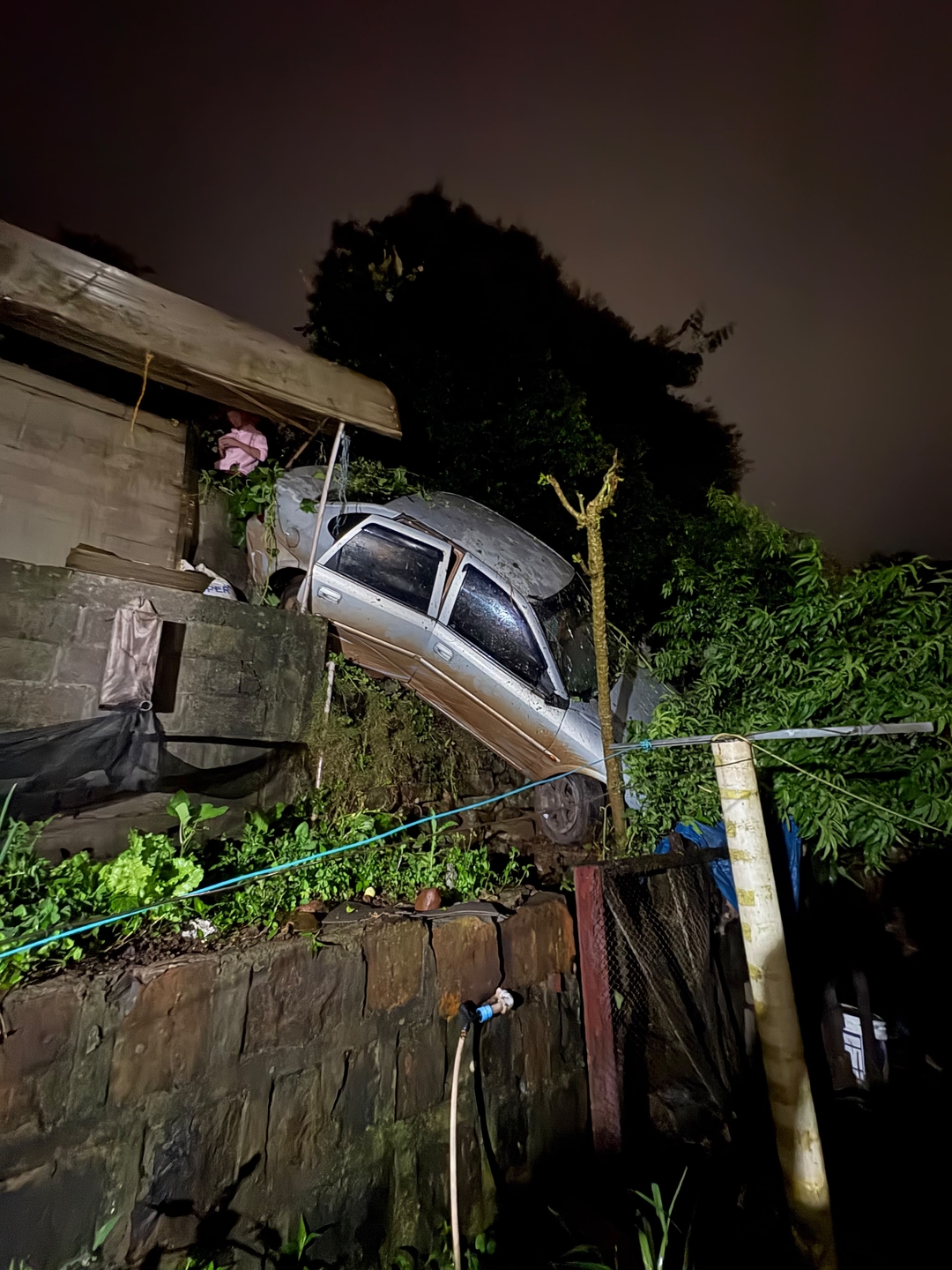 Carro sai da pista e cai em barranco nos fundos de residência em Modelo