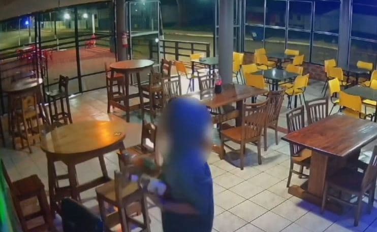 Suspeito com bebidas nas mãos (Foto: Divulgação)