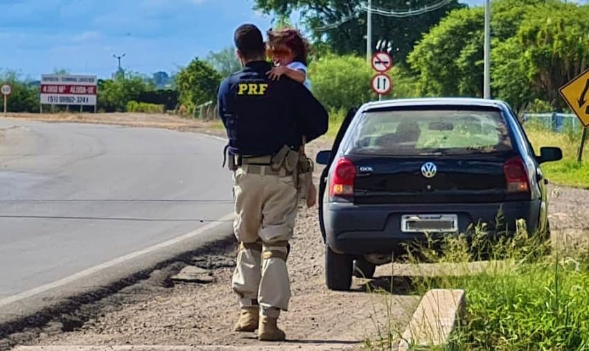 PRF levando menina para local seguro (Foto: Polícia Rodoviária Federal)