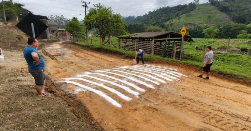 Obra inusitada: estrada de terra é pintada para simular lombadas