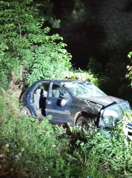Veículo sai da pista, colide em barranco e fica sustentado por árvore