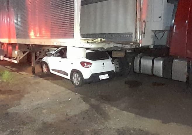 Automóvel parou embaixo do veículo de carga (Foto: Corpo de Bombeiros)