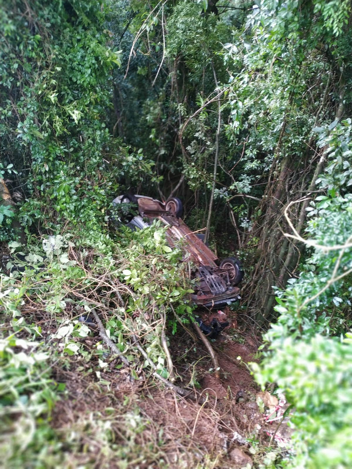 Carro cai em ribanceira após colidir com carreta