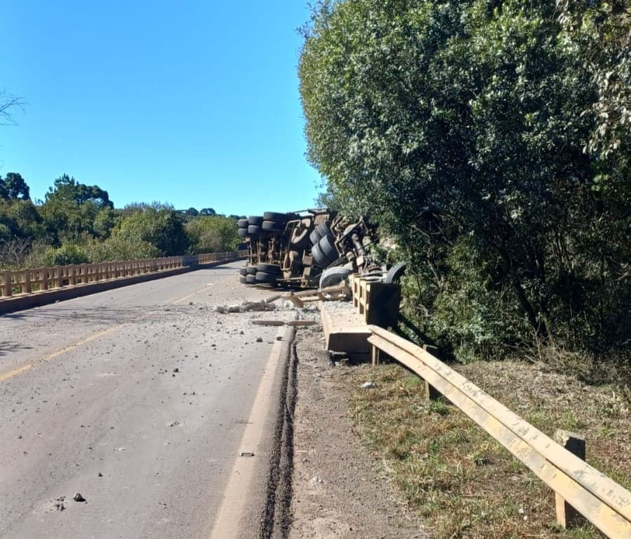 Caminhoneiro tem parte do corpo soterrado por carga em capotamento