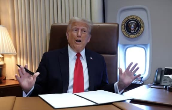 Presidente dos EUA, Donald Trump, fala no avião presidencial, neste domingo (9) (Foto: Kevin Lamarque)